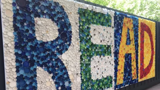 A mural made of colourful bottlecaps on a wall, which spells out 'read'