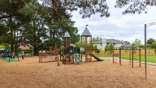 Playground showing pullup bars and timber unit with play shop front and slide