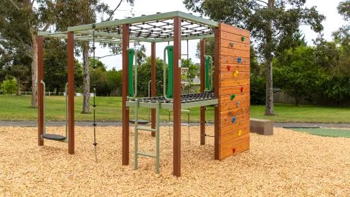 Climbing structure including climbing wall and nets above a timber structure