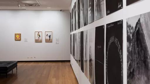 two frames with photos of people giving piggybacks. A wall of black and while indistinguishable images all hung close together