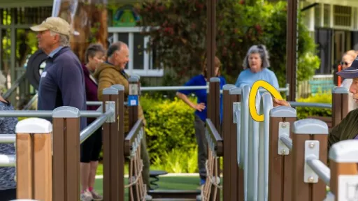 senior men and women using outdoor exercise equipment