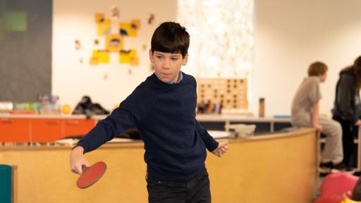 A young person playing table tennis at the youth hub.