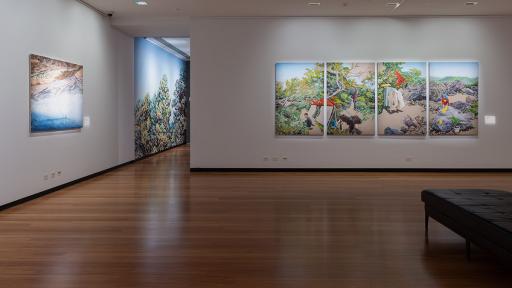 Photograph of large landscape paintings hanging in a gallery