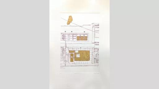 An etching of a shopfront with a bird in the window and on top of the building. Features sections of gold leaf.