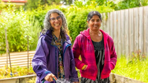 Two people watering a community garden