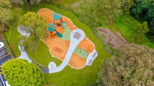 Aerial view of a playground surrounded by green grass and trees