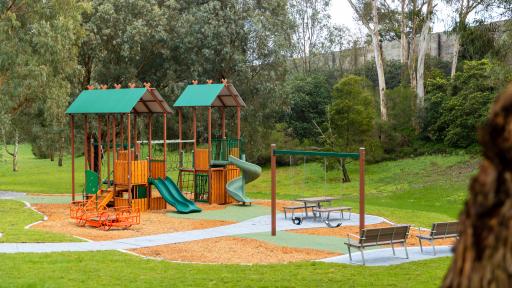 a playground with 2 slides under cover and various seats