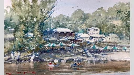 Watercolour painting of a boathouse by the river. There are small boast in the river in the foreground.