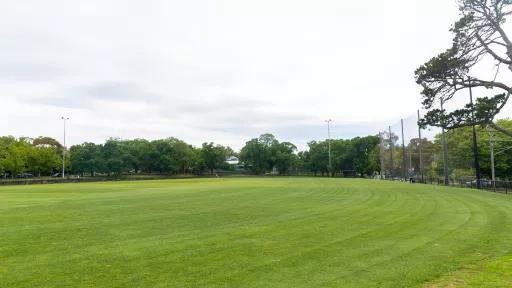 A grassy green sports oval with goal posts