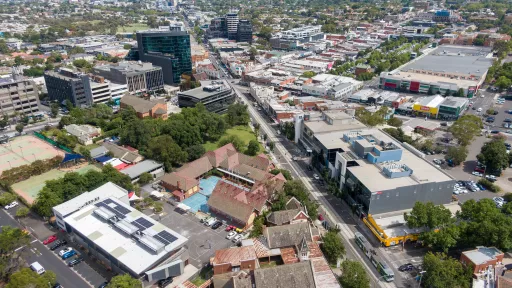 An aerial view of the Camberwell Civic Precinct, showing the surrounding landscape. The area is filled with buildings, trees, and pathways, making it a vibrant and welcoming public space. 