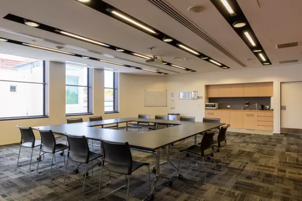 A carpeted room with U-shaped table 